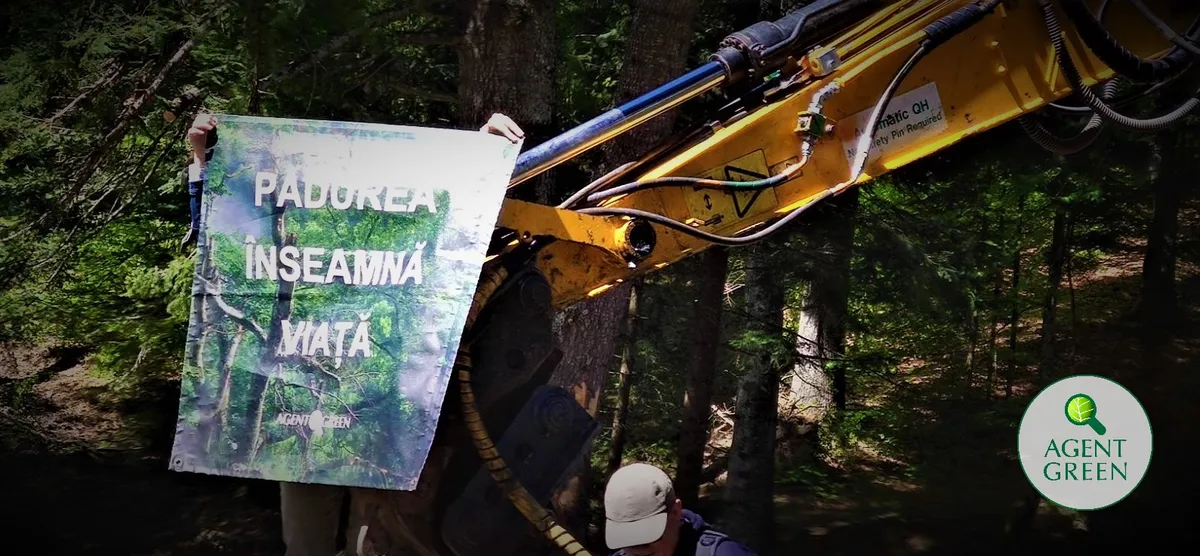 Ein Banner „Pădurea înseamnă viață“ neben einer Forstmaschine, mit dem Logo von Agent Green.