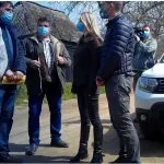 Grup de bărbați discutând lângă un autoturism.