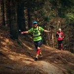 Due persone che corrono su un sentiero forestale.