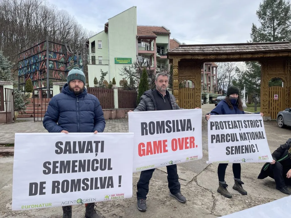 Three people with placards calling for Semenic’s protection in front of a building.