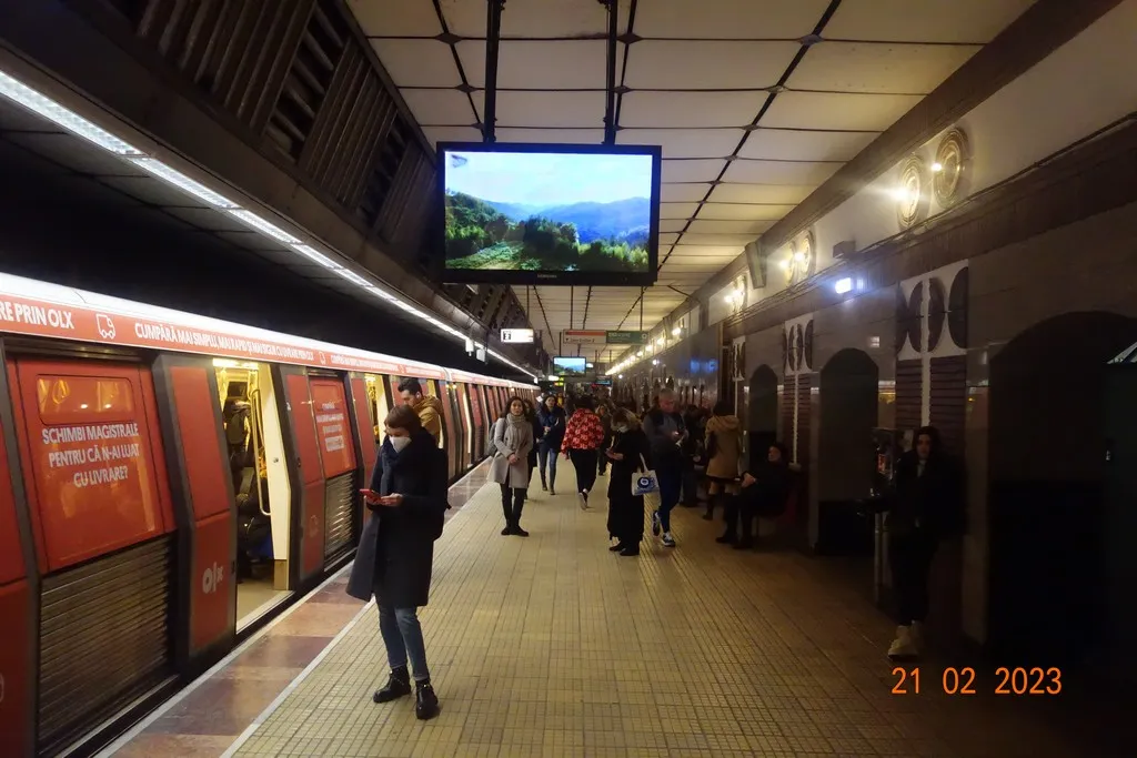Treno e banchina della metropolitana con uno schermo della campagna Pădurea Mea