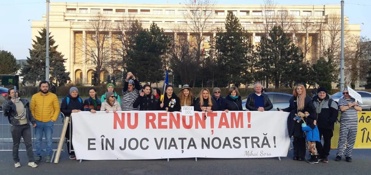 Menschen vor einem Regierungsgebäude mit dem Banner „Wir geben nicht auf! Unser Leben steht auf dem Spiel!“