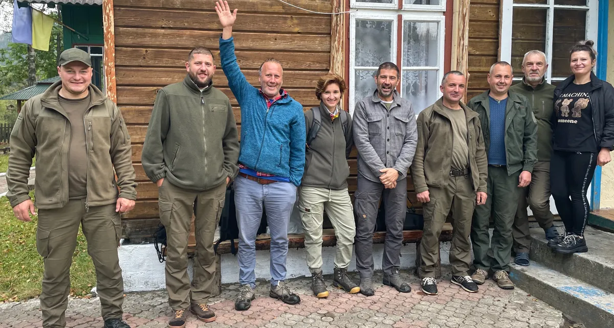 Eine Gruppe von Menschen vor einem Holzgebäude.