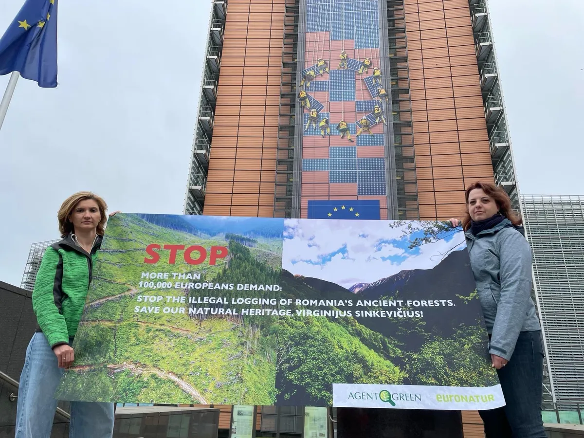 Zwei Teilnehmerinnen halten vor dem Berlaymont-Gebäude ein Banner für Rumäniens Wälder